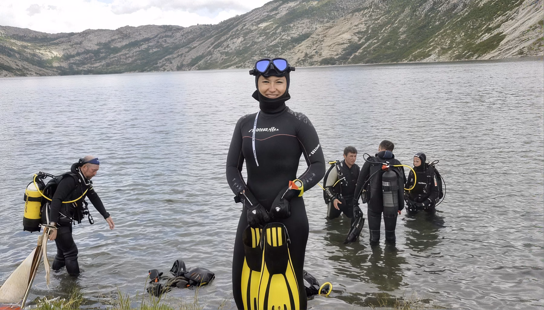 Scuba divers by a mountain lake